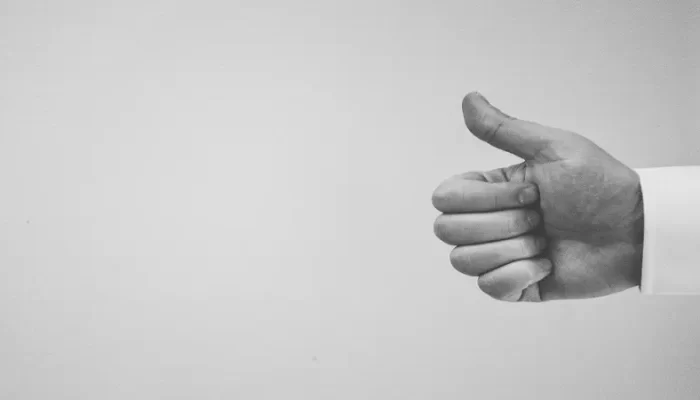 Black and white photo of a thumbs up.