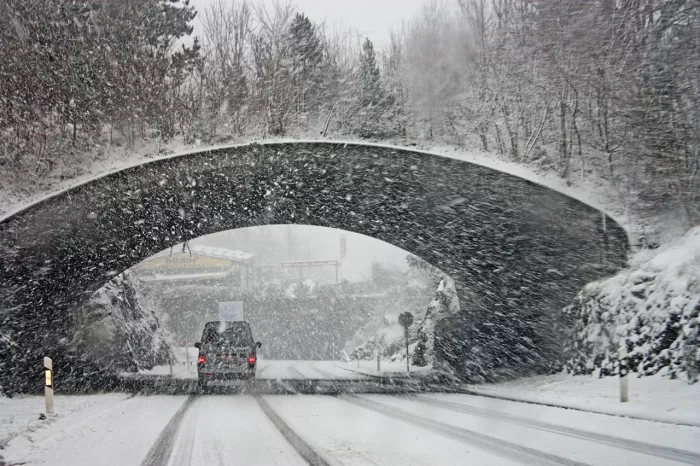 Van driving under bridge is heavy snow