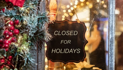 'closed for the holidays' sign on the front window of a business, with a reef on the side.