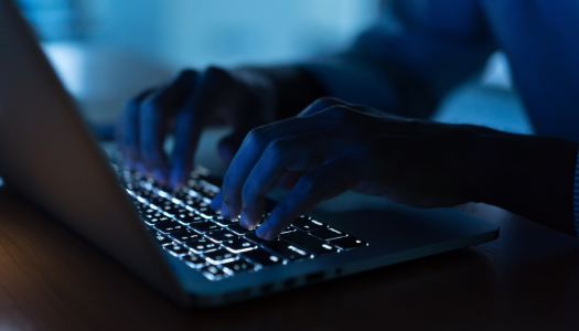Pair of hands typing on a laptop