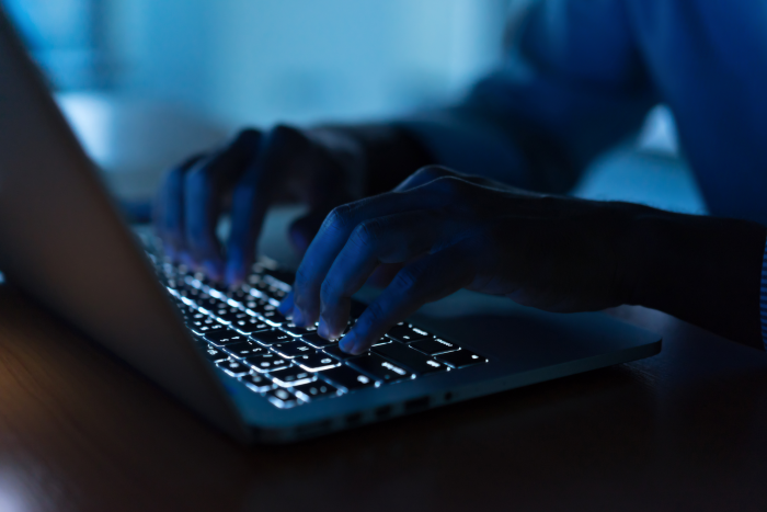 Pair of hands typing on a laptop