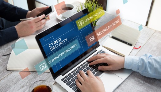 Person on laptop. On laptop it says 'cyber security', with further quotations coming off of the laptop saying 'computer security', 'secure payment' and 'online privacy'.